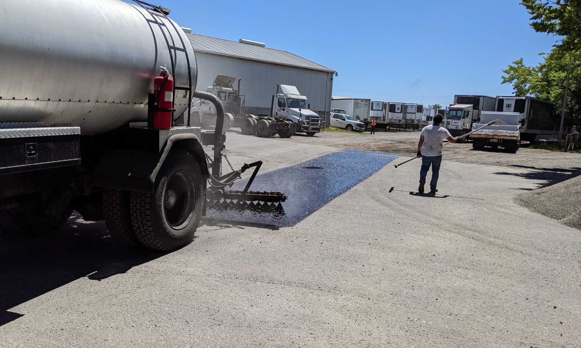 Chip seal oil being applied to parking lot